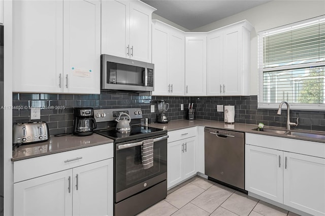 690 Drop, Shot, FL 33896 - kitchen with stainless steel appliances, light tile patterned floors, a sink, and backsplash