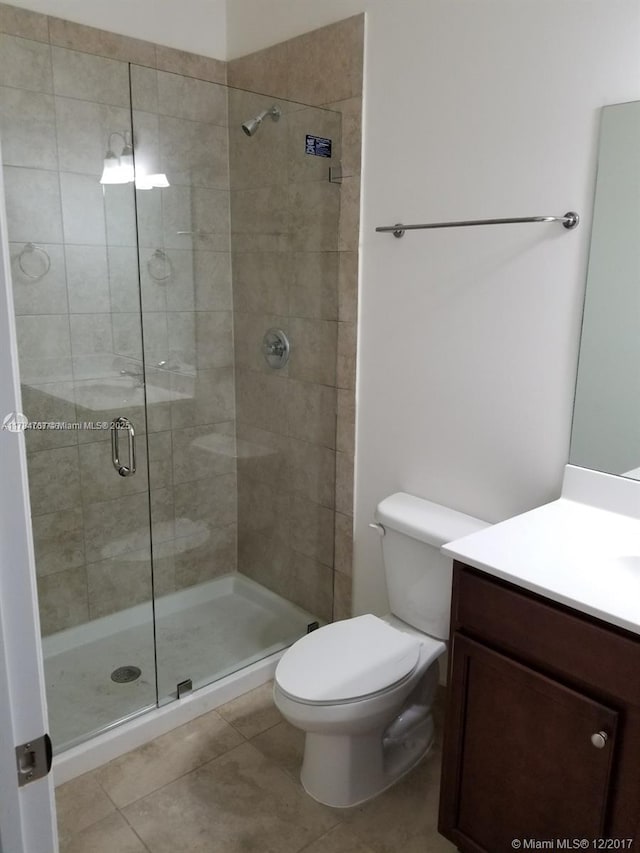 290 NW 109th Ave Unit 216, Miami, FL 33172 - bathroom featuring toilet, tile patterned floors, vanity, and a stall shower