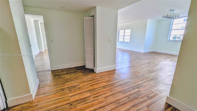 300 Bayview Dr Unit 206, Sunny Isles Beach, FL 33160 - unfurnished room with wood finished floors, a chandelier, and baseboards