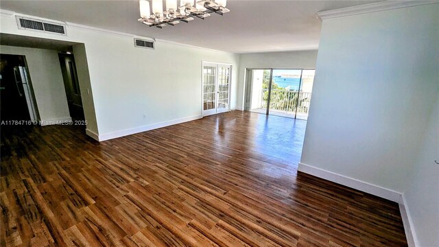 300 Bayview Dr Unit 206, Sunny Isles Beach, FL 33160 - spare room featuring ornamental molding, dark wood finished floors, baseboards, and a chandelier