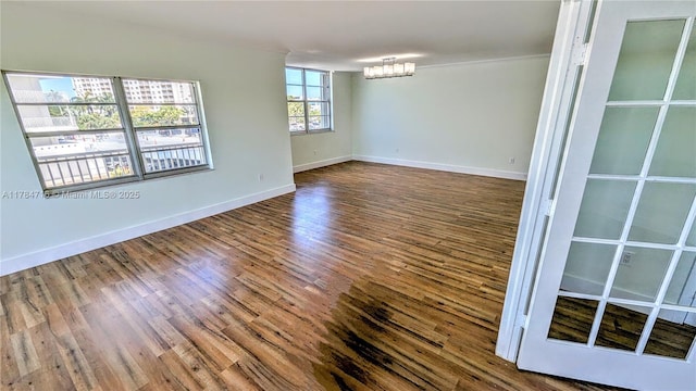 300 Bayview Dr Unit 206, Sunny Isles Beach, FL 33160 - empty room with a chandelier, wood finished floors, baseboards, and ornamental molding