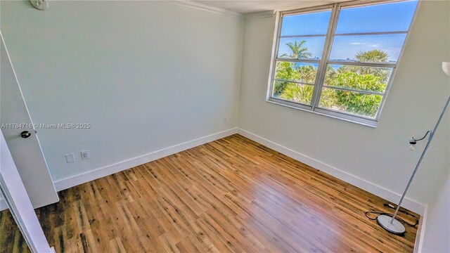 300 Bayview Dr Unit 206, Sunny Isles Beach, FL 33160 - spare room with baseboards, crown molding, and wood finished floors