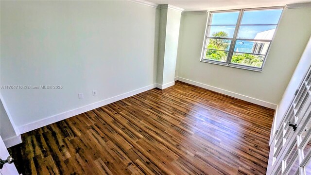 300 Bayview Dr Unit 206, Sunny Isles Beach, FL 33160 - spare room featuring ornamental molding, baseboards, and dark wood-style floors