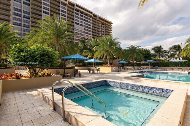 community pool featuring a patio area and a community hot tub
