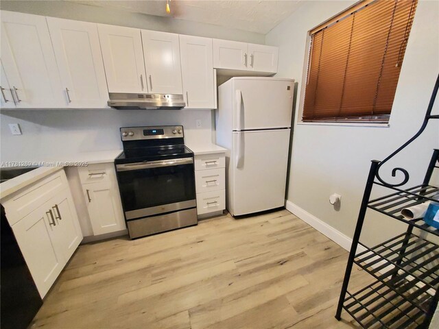 16750 NE 10th Ave Unit 326, North Miami Beach, FL 33162 - kitchen with stainless steel electric range, freestanding refrigerator, under cabinet range hood, light countertops, and white cabinetry