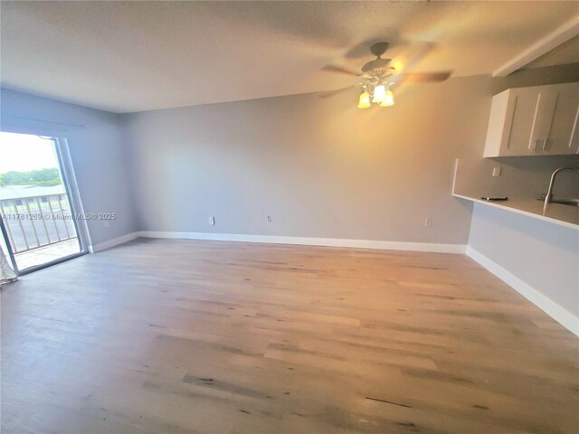16750 NE 10th Ave Unit 326, North Miami Beach, FL 33162 - kitchen featuring ceiling fan, light wood-style floors, a sink, stainless steel range with electric stovetop, and beam ceiling
