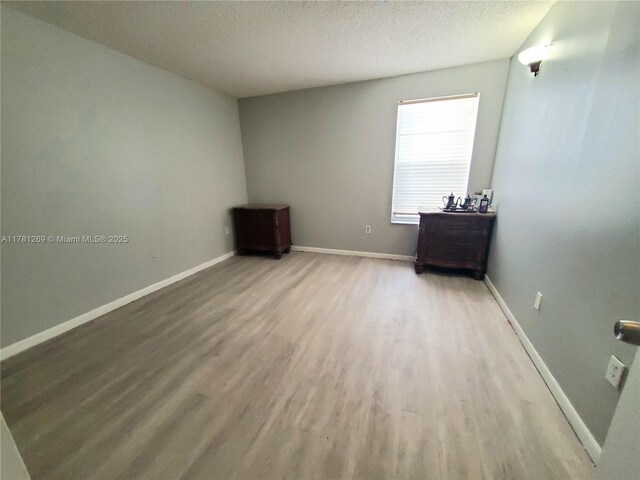 16750 NE 10th Ave Unit 326, North Miami Beach, FL 33162 - unfurnished bedroom with light wood finished floors, baseboards, a sink, and ensuite bath
