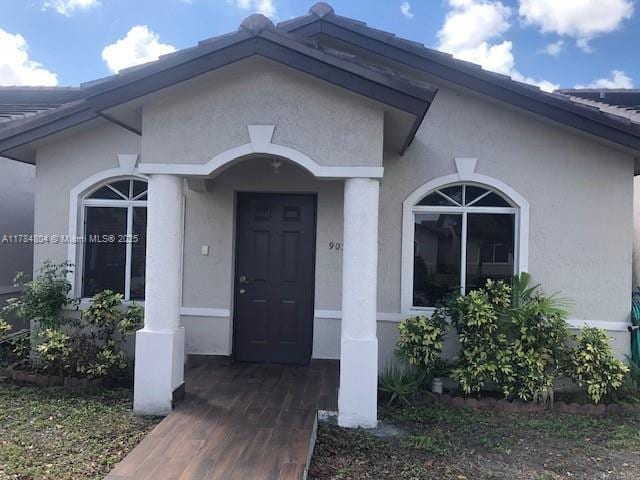 entrance to property featuring stucco siding
