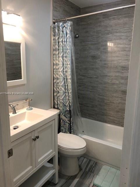 bathroom featuring shower / tub combo, toilet, and vanity