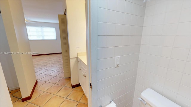 bathroom featuring toilet, tile patterned floors, vanity, and baseboards