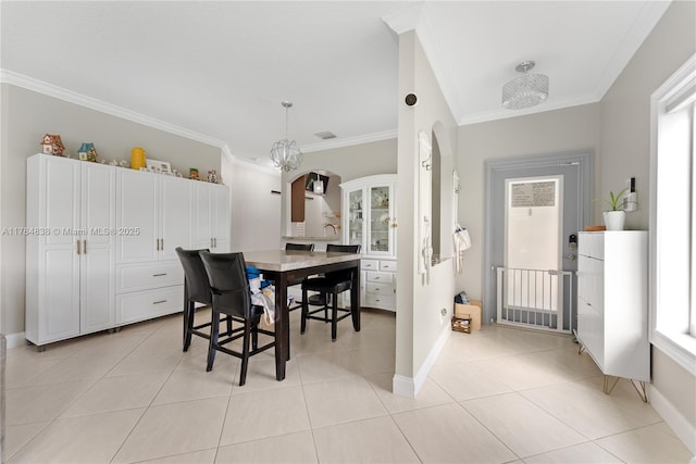 dining room with arched walkways, baseboards, and ornamental molding