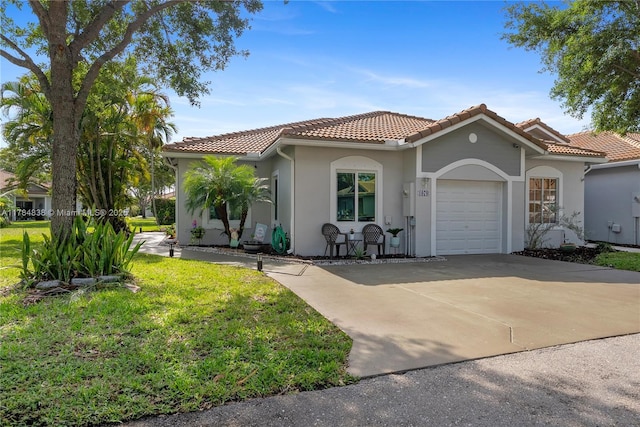 mediterranean / spanish-style house featuring stucco siding, driveway, a front yard, a tile roof, and a garage