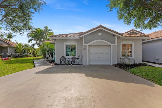 mediterranean / spanish home featuring a tiled roof, stucco siding, a front lawn, a garage, and concrete driveway