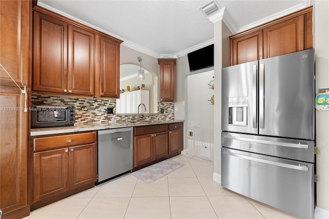 kitchen with visible vents, a sink, ornamental molding, appliances with stainless steel finishes, and backsplash