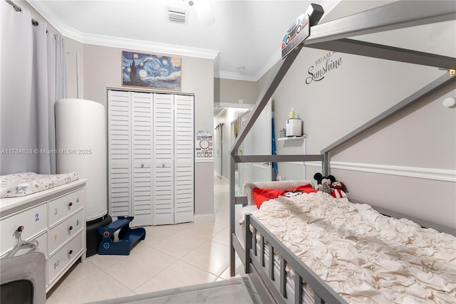bedroom with crown molding, light tile patterned floors, a closet, and visible vents