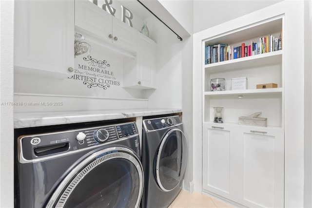 washroom with cabinet space, light tile patterned floors, and washer and dryer