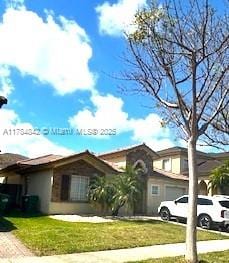 9418 SW 227th Ter, Cutler Bay, FL 33190 - mediterranean / spanish home with driveway, a garage, and a front yard