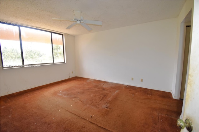 carpeted spare room with ceiling fan and baseboards
