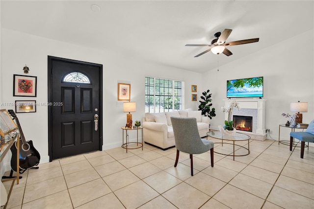 17746 48th Ct N, Loxahatchee, FL 33470 - living room featuring a warm lit fireplace, a ceiling fan, light tile patterned flooring, and lofted ceiling