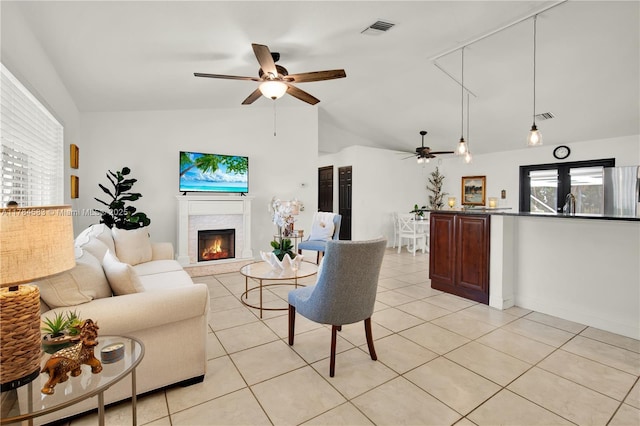 17746 48th Ct N, Loxahatchee, FL 33470 - living area with ceiling fan, lofted ceiling, a lit fireplace, and light tile patterned floors