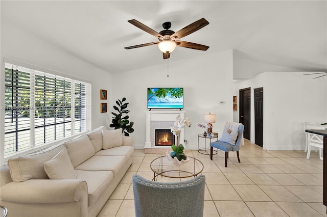 17746 48th Ct N, Loxahatchee, FL 33470 - living room featuring lofted ceiling, a ceiling fan, light tile patterned flooring, and a warm lit fireplace