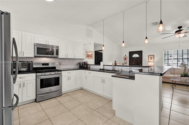 17746 48th Ct N, Loxahatchee, FL 33470 - kitchen with appliances with stainless steel finishes, a peninsula, open floor plan, light tile patterned floors, and tasteful backsplash
