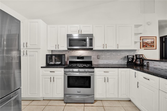 17746 48th Ct N, Loxahatchee, FL 33470 - kitchen featuring stainless steel appliances, light tile patterned floors, tasteful backsplash, white cabinets, and lofted ceiling