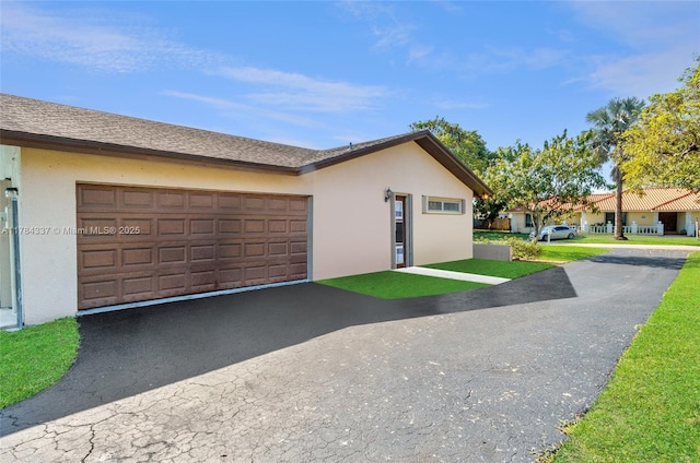 view of front facade featuring driveway, stucco siding, and a garage