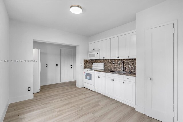 301 E 35th St, Hialeah, FL 33013 - kitchen featuring tasteful backsplash, light wood-type flooring, white appliances, white cabinetry, and a sink