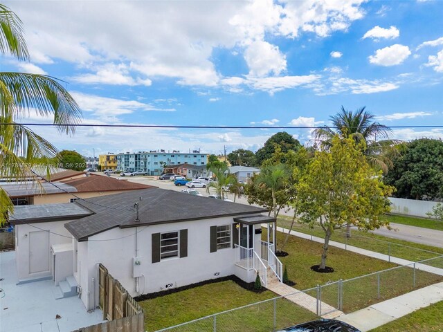 301 E 35th St, Hialeah, FL 33013 - exterior space with a shingled roof, a fenced backyard, stucco siding, and a front yard