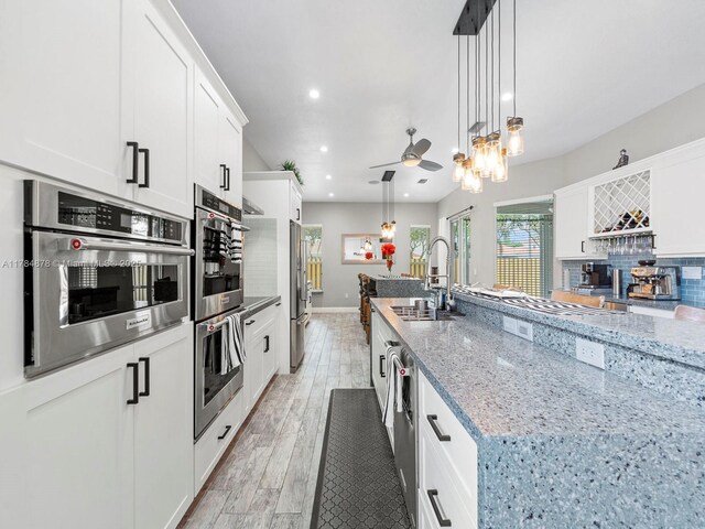 2021 SE 17th Ave, Homestead, FL 33035 - kitchen with appliances with stainless steel finishes, a sink, white cabinets, light stone counters, and recessed lighting