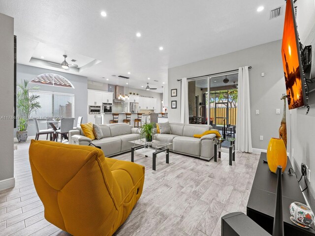 2021 SE 17th Ave, Homestead, FL 33035 - living area with recessed lighting, baseboards, ceiling fan, light wood-type flooring, and a tray ceiling