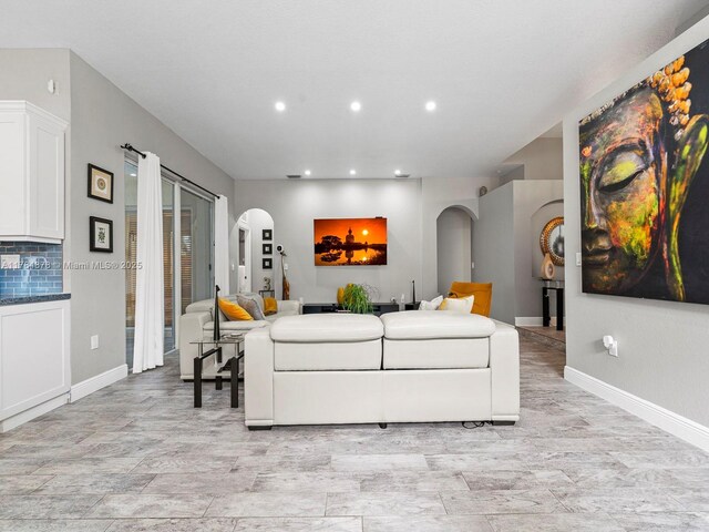 2021 SE 17th Ave, Homestead, FL 33035 - living room with arched walkways, recessed lighting, baseboards, and light wood-style floors