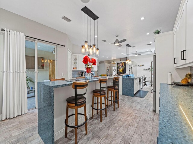 2021 SE 17th Ave, Homestead, FL 33035 - kitchen featuring an island with sink, a ceiling fan, light wood-type flooring, recessed lighting, and white cabinetry