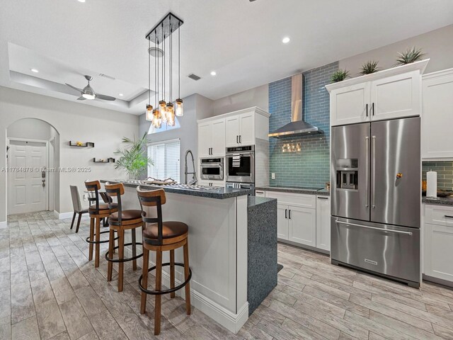 2021 SE 17th Ave, Homestead, FL 33035 - kitchen featuring stainless steel appliances, wall chimney range hood, light wood-type flooring, tasteful backsplash, and recessed lighting