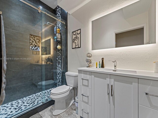 2021 SE 17th Ave, Homestead, FL 33035 - full bath featuring a textured wall, toilet, vanity, and a shower stall