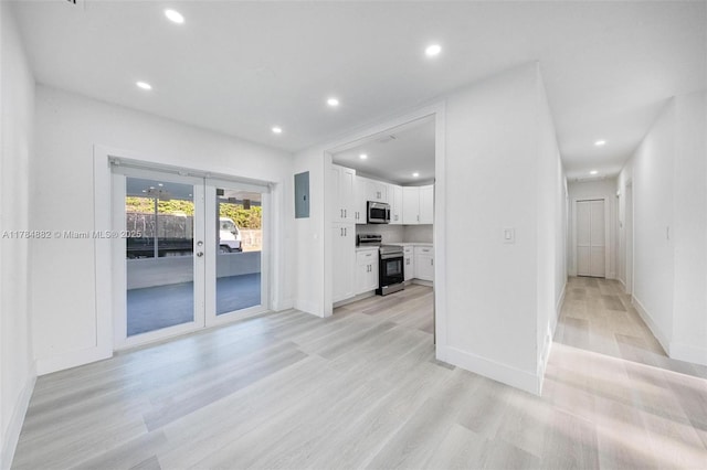 unfurnished living room with baseboards, electric panel, recessed lighting, french doors, and light wood-style flooring