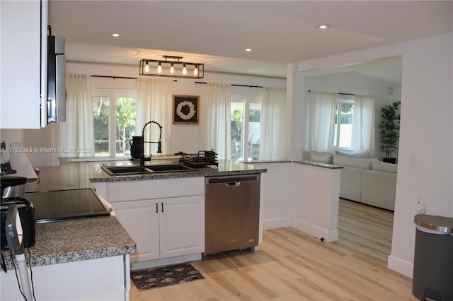 kitchen featuring a sink, light wood-style floors, a healthy amount of sunlight, white cabinetry, and dishwasher
