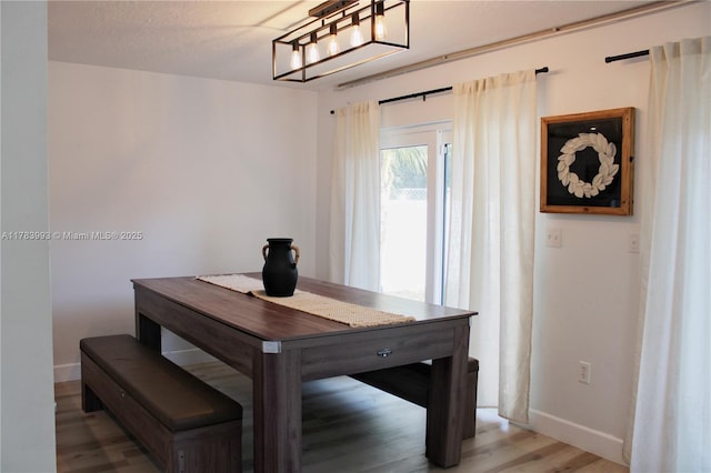 dining space with baseboards and light wood-style floors