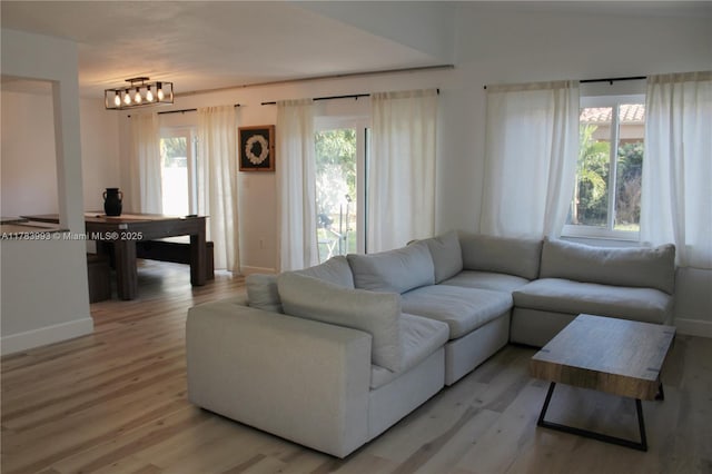 living area featuring light wood finished floors and baseboards
