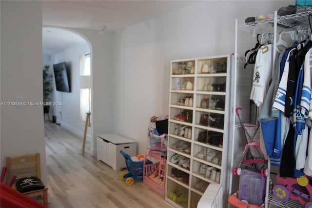 interior space featuring radiator heating unit, wood finished floors, and arched walkways