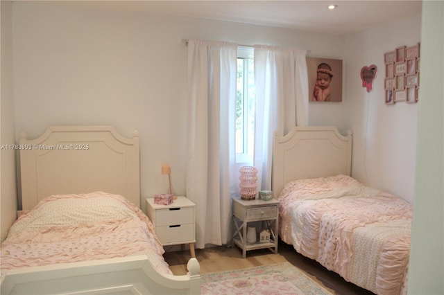 bedroom with recessed lighting and wood finished floors