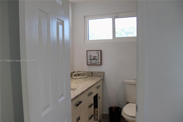 half bathroom with vanity and toilet