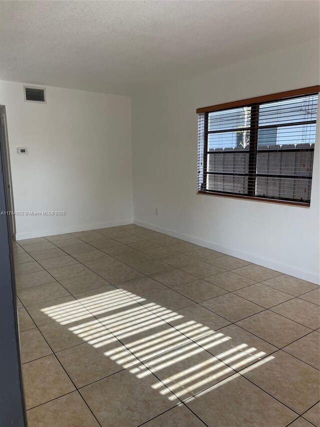 271 NW 57th Ct, Miami, FL 33126 - empty room with visible vents, baseboards, and tile patterned flooring