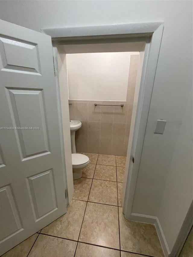 271 NW 57th Ct, Miami, FL 33126 - bathroom with tile patterned floors, tile walls, and toilet