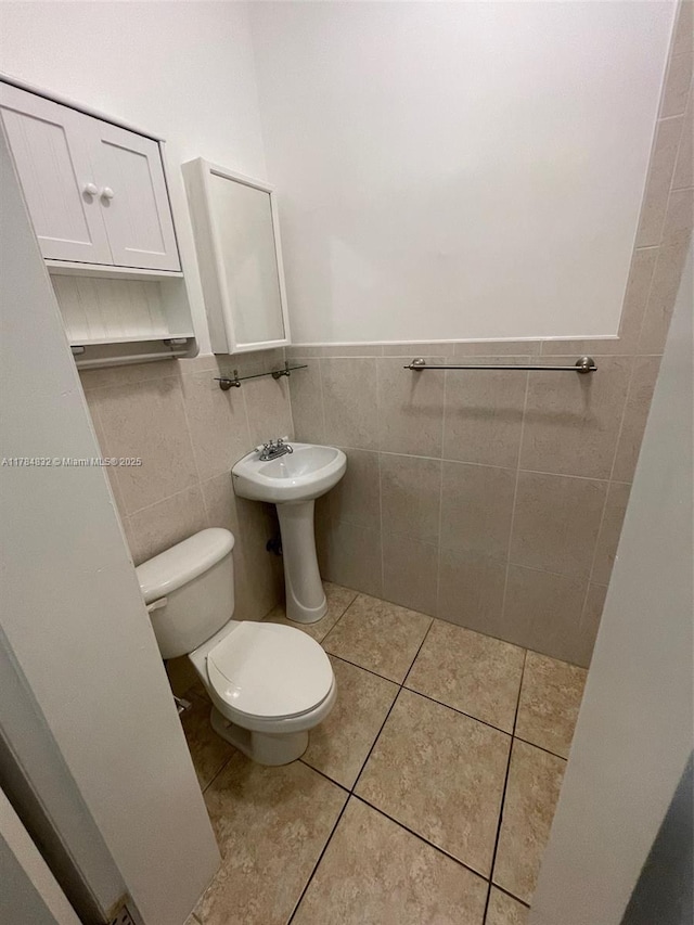 271 NW 57th Ct, Miami, FL 33126 - bathroom with a wainscoted wall, toilet, a sink, tile walls, and tile patterned floors