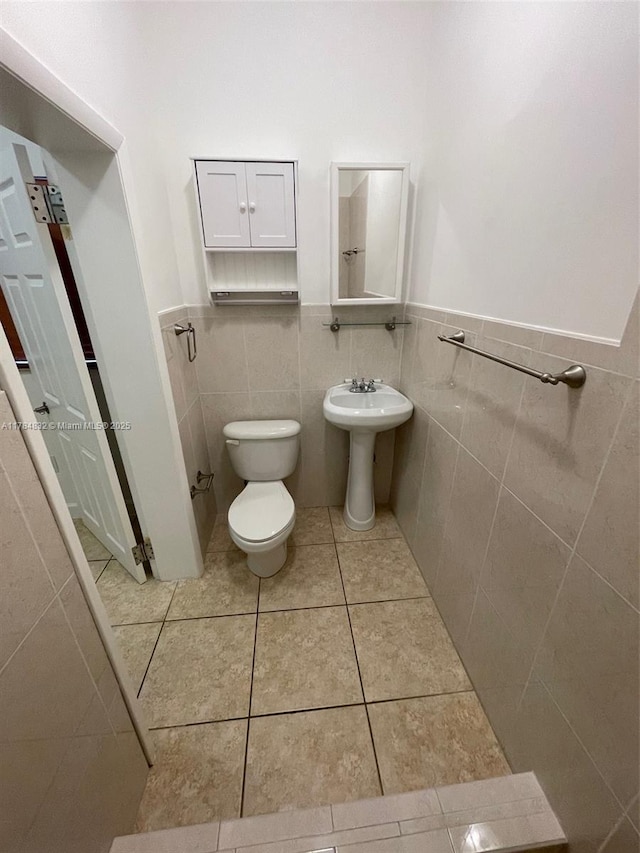 271 NW 57th Ct, Miami, FL 33126 - half bath featuring toilet, tile walls, tile patterned floors, and a wainscoted wall
