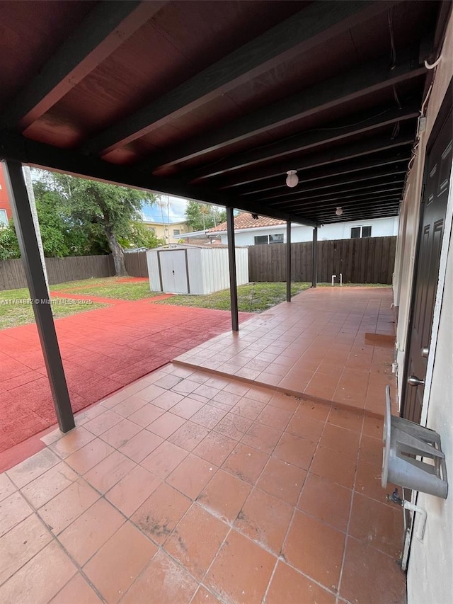 271 NW 57th Ct, Miami, FL 33126 - view of patio featuring a storage shed, a carport, an outbuilding, and a fenced backyard