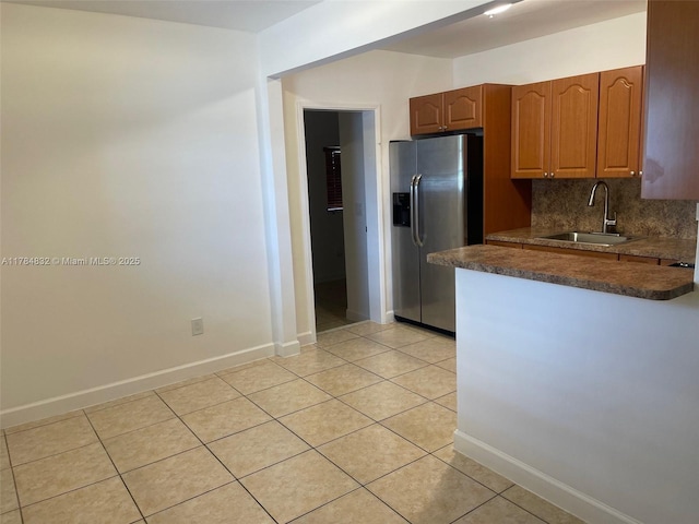 271 NW 57th Ct, Miami, FL 33126 - kitchen featuring light tile patterned floors, tasteful backsplash, stainless steel refrigerator with ice dispenser, dark countertops, and a sink