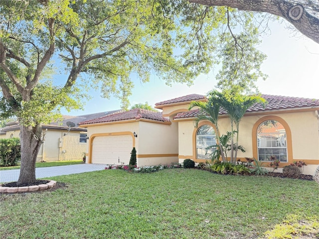 5352 NW 57th Ter, Coral Springs, FL 33067 - mediterranean / spanish-style home with a front yard, an attached garage, driveway, stucco siding, and a tiled roof